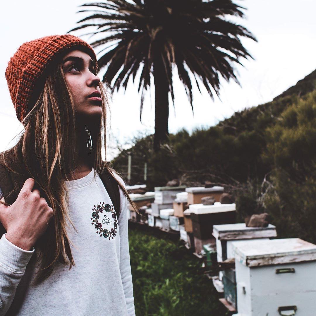 fille portant un pull bee zen à côté de ruches